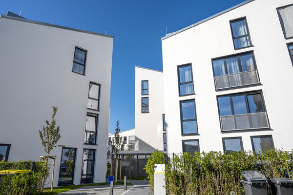 Weiße Wohnhäuser im Hintergrund als Zeichen für die Immobilieninvestitionen